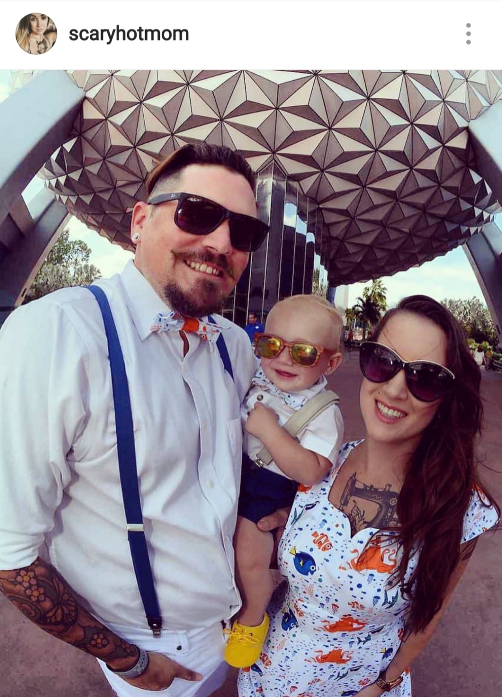 family dressed in coordinating finding Nemo outfits with spaceship earth behind them all in sunglasses