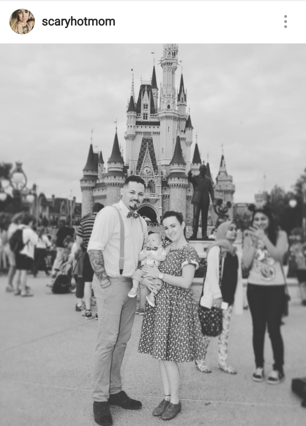 black and white picture of family in front of cinderella castle