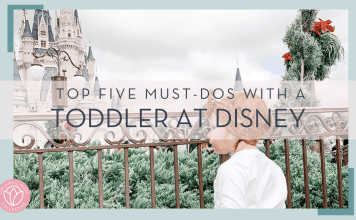 little girl in front of cinderella castle at the fence with 'top five must-dos with a toddler at disney' in font in front of image