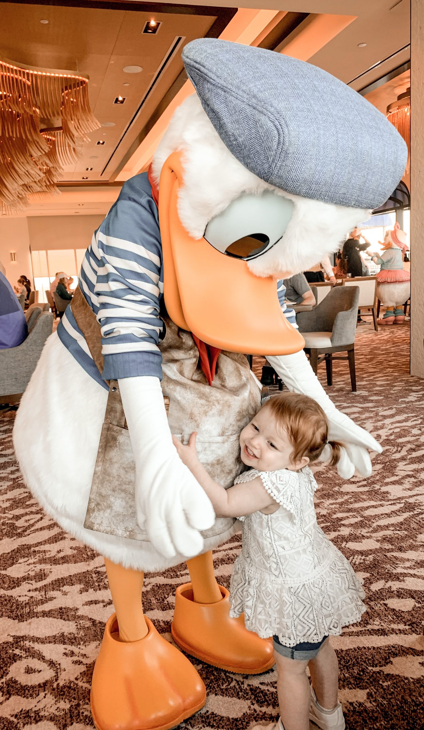little girl hugging Donald Duck with a barett on