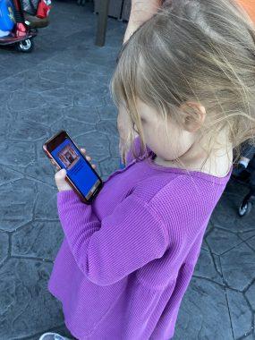 Girl in purple playing Ducktales on a phone