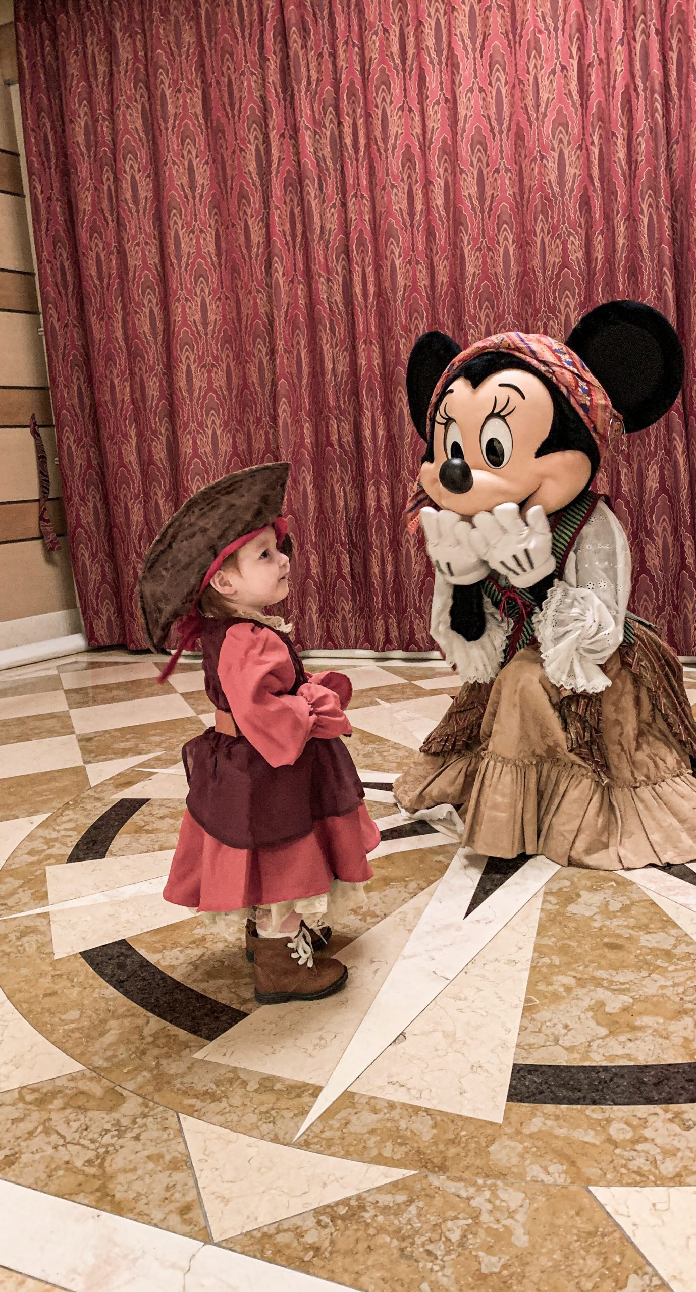 little girl dressed as a pirate meeting Minnie Mouse in her pirate outfit