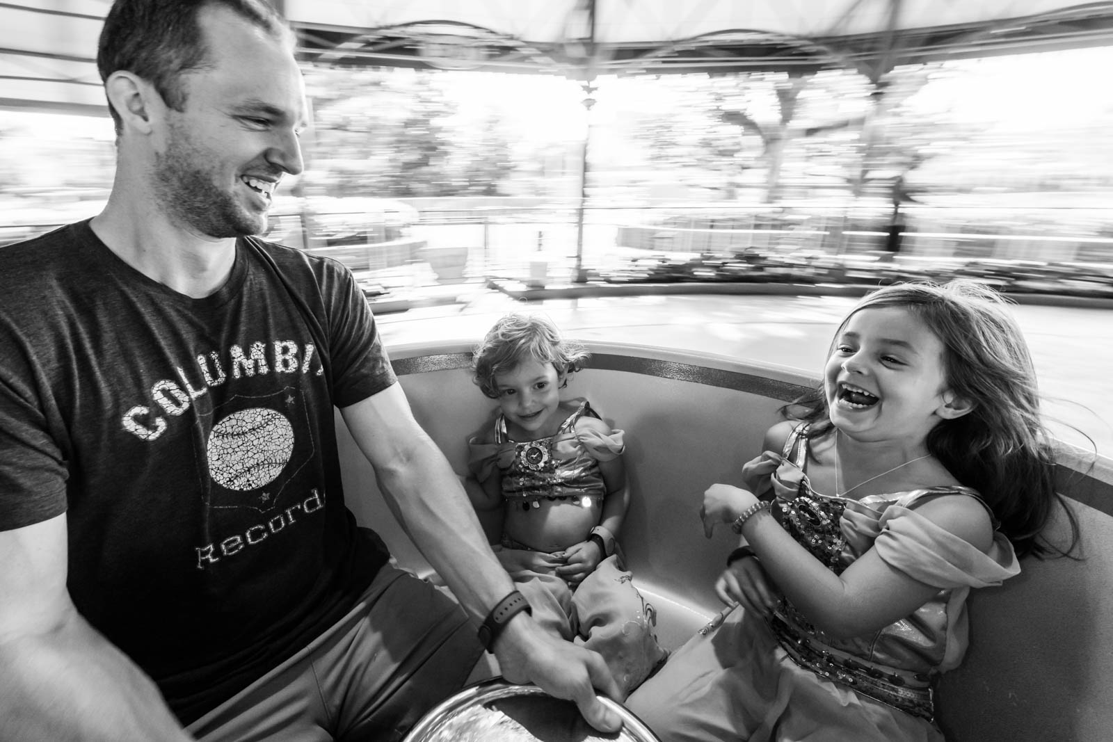 dad and two kids spinning on the teacups at magic kingdom