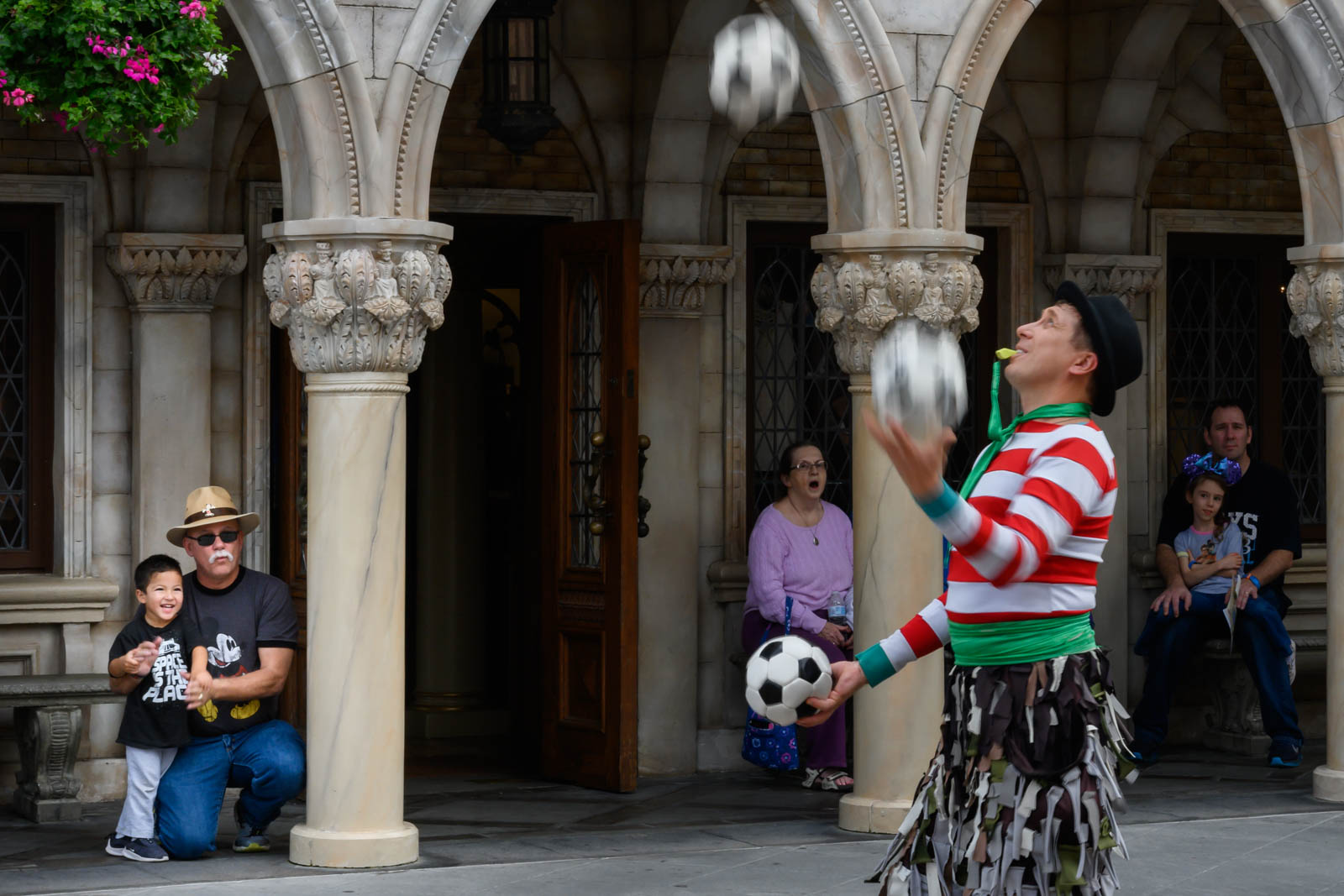 man juggling soccer balls with a whistle in his mouth