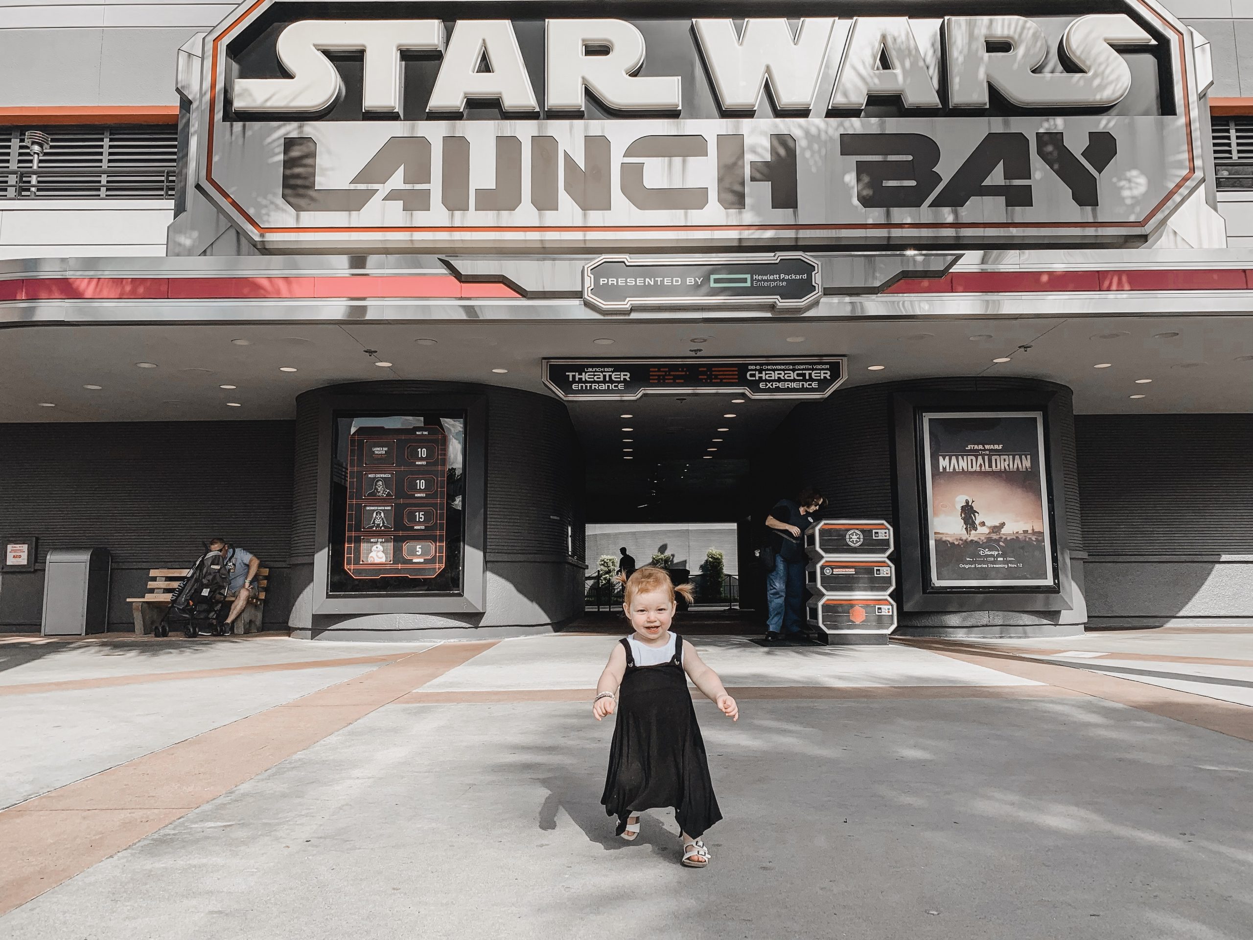 little girl in front of 'Star Wars launch bay'