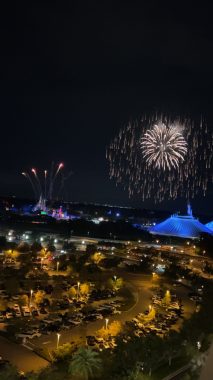 fireworks over a lit up cinderella castle and space mountain