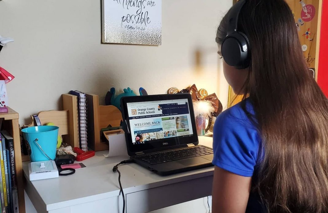 Tween girl doing virtual school on her laptop