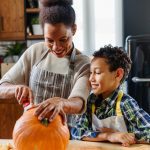 Mother and son carving pumpkin making Jack-o-Lantern