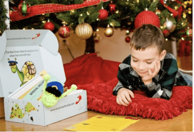 child reading mail under christmas tree