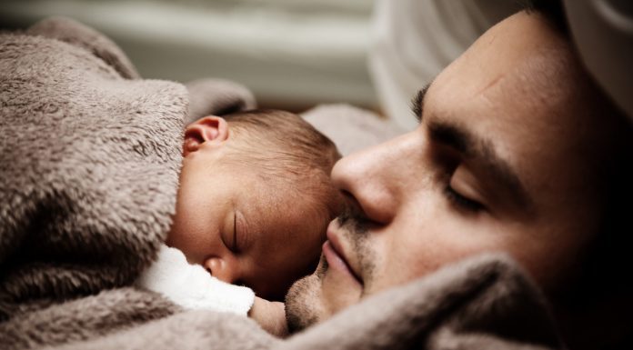father laying down with newborn on chest