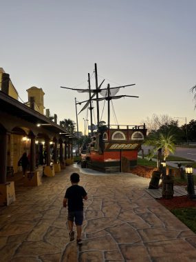 Pirate Dinner Adventure; bow walking toward a pirate ship at dusk