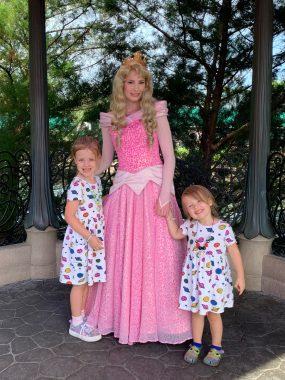 Two little girls meeting princess Aurora in pink dress