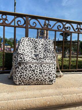 My Freshly Picked Classic Diaper Bag II in leopard print with fence and Cinderella Castle behind it