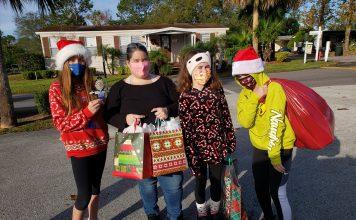 A group of tween girls sharing Christmas toys and gifts for Nathaniel's Hope Caroling Caravan in 2020