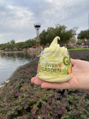 yellow ice cream in International Flower & Garden Festival cup in hand with lagoon behind
