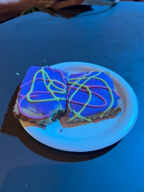 pastry with blue icing with yellow and purple swirls on top