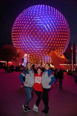 three women with spaceship earth behind them