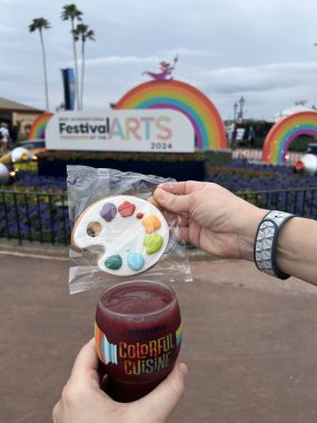 artist pallet cookie and purple slushy with Festival of the Arts sign behind with a rainbow