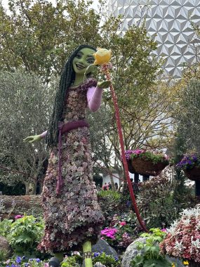 Asha, from Wish, topiary made from succulents with spaceship earth behind her