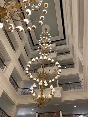 circular chandeliers looking up into hotel