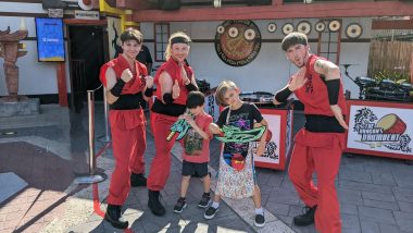 two kids with three men in ninja red outfits