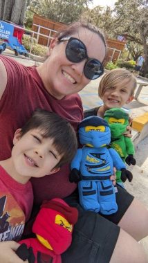 mom in sunglasses, two boys with red, blue and green stuffed lego men