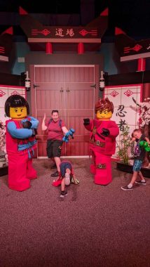 mom and two boys with two large lego men