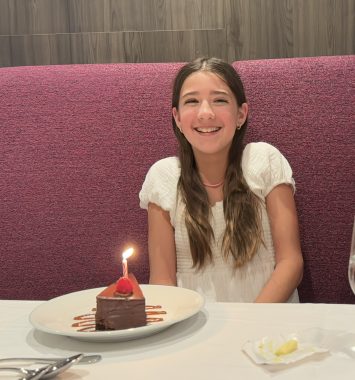 young girl smiling at camera with birthday cake 
