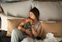 mom cuddling newborn baby in bed. Beauty and Wellness Tips for Postpartum Recovery