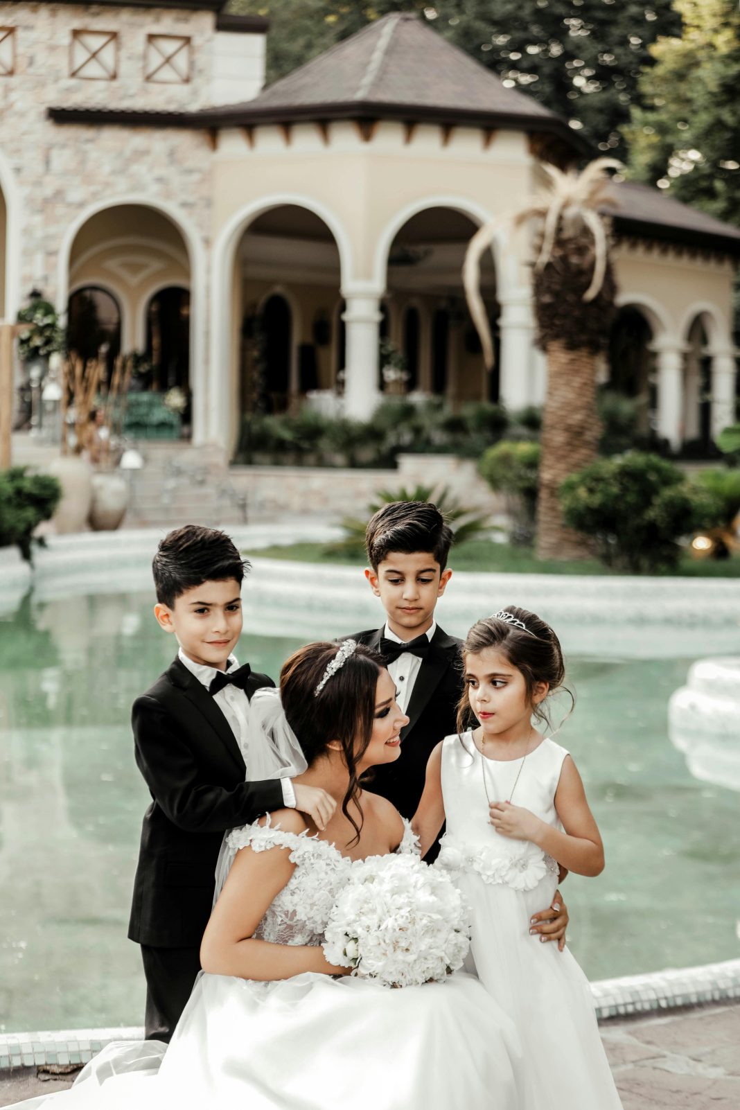bride surrounded by children, smiling. 9 Tips for Bringing Your Kids to a Wedding