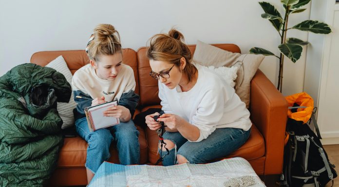 mom and daughter looking at a map and writing notes down for a pre travel checklist